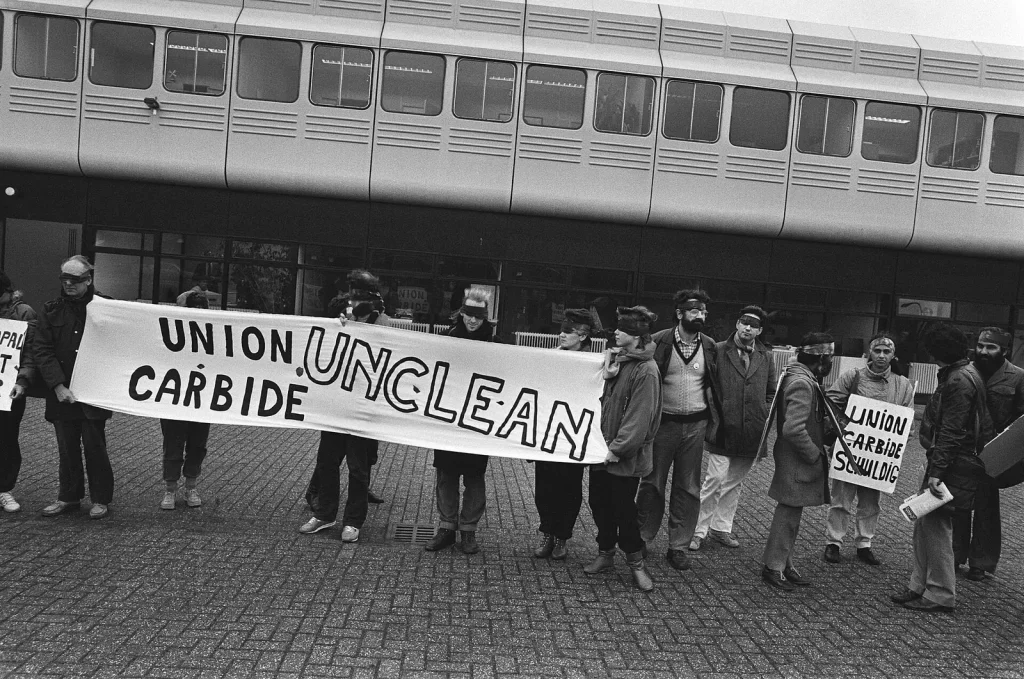 Демонстранты держат плакат «Union Carbide unclean» перед зданием в Лейдердорпе