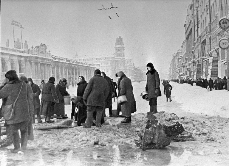 Блокада Ленинграда: ленинградцы набирают воду из воронки на Невском проспекте у Гостиного двора, декабрь 1941 года