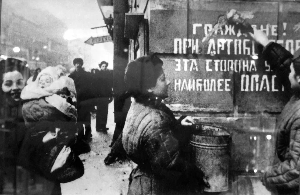 Надпись «Граждане! При артобстреле эта сторона улицы наиболее опасна» закрашивают после снятия блокады, 1944 год
