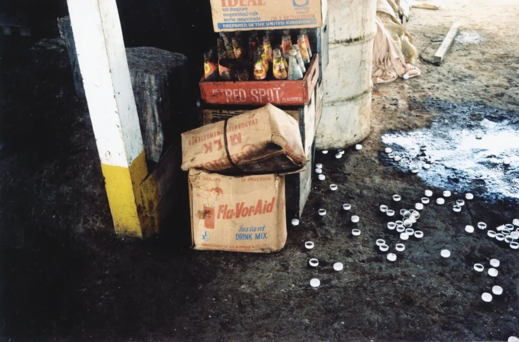 Коробка порошкового напитка Flavor Aid и бутылки на земле в Джонстауне, 1978 год
