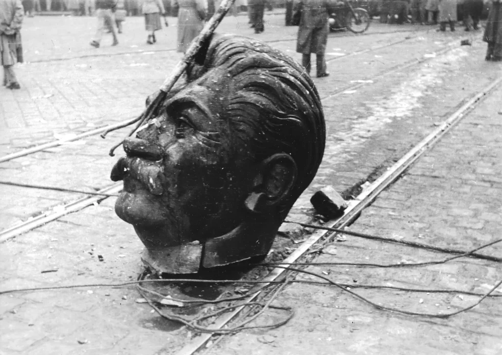 Голова сваленной статуи Сталина лежит на мостовой Большого кольца в Будапеште, октябрь 1956 года