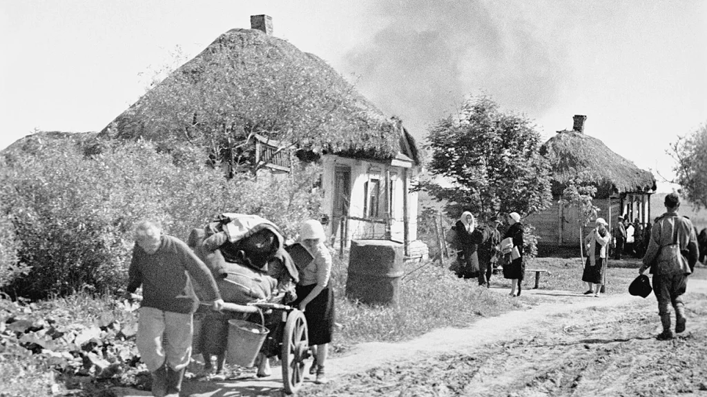 Мирные жители с тачкой покидают дома на окраине Курска, июль 1943 года