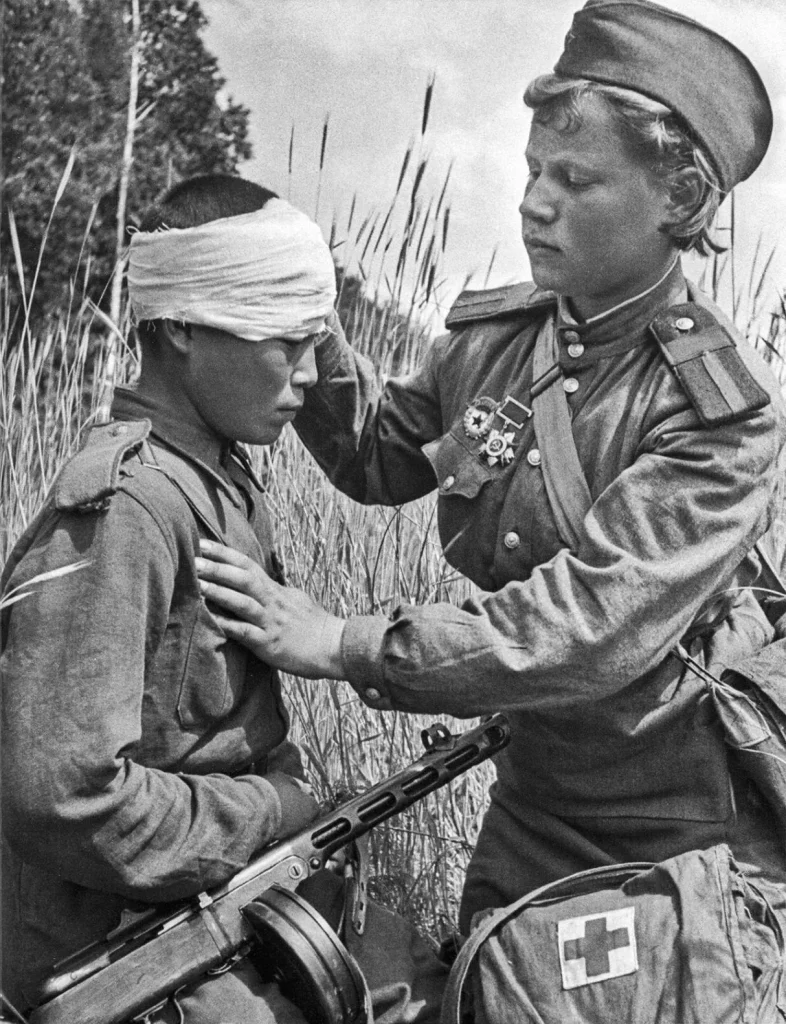 Санинструктор В. И. Кемаева перевязывает раненого бойца на Воронежском фронте, июль 1943 года