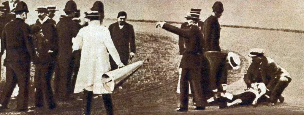 Упавший Дорандо Пьетри на дорожке стадиона, над ним врачи и судьи, 1908 год