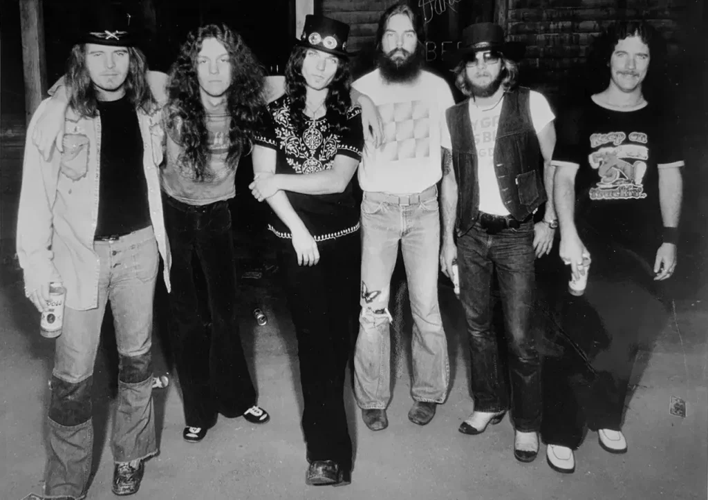 Lynyrd Skynyrd, рекламное фото MCA 1976 года: шестеро музыкантов на улице с банками пива