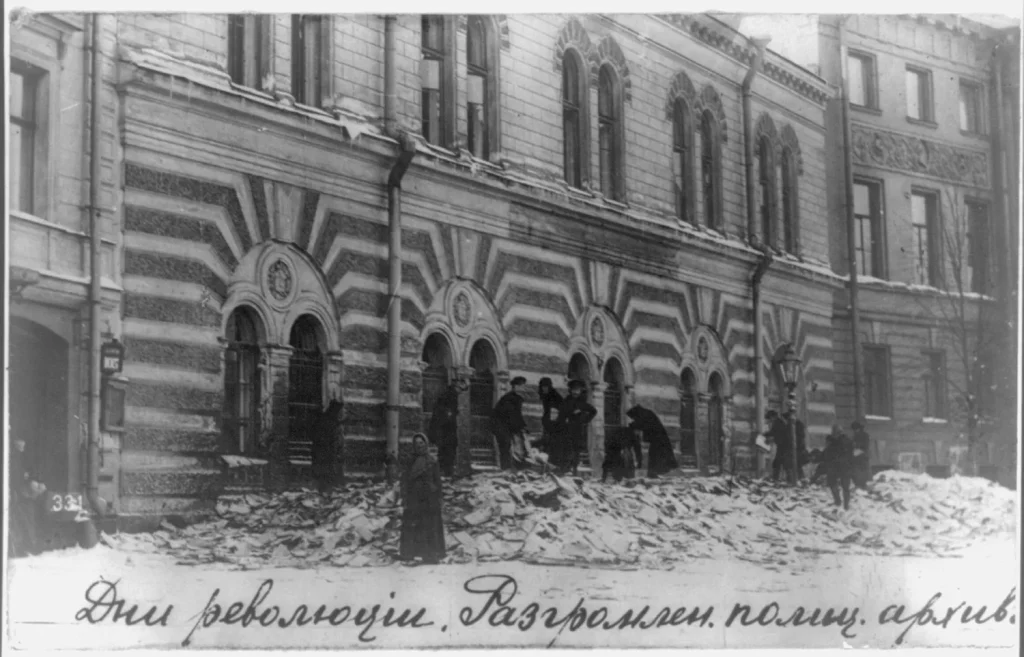 Улица перед разгромленным полицейским участком, на снегу разбросаны бумаги