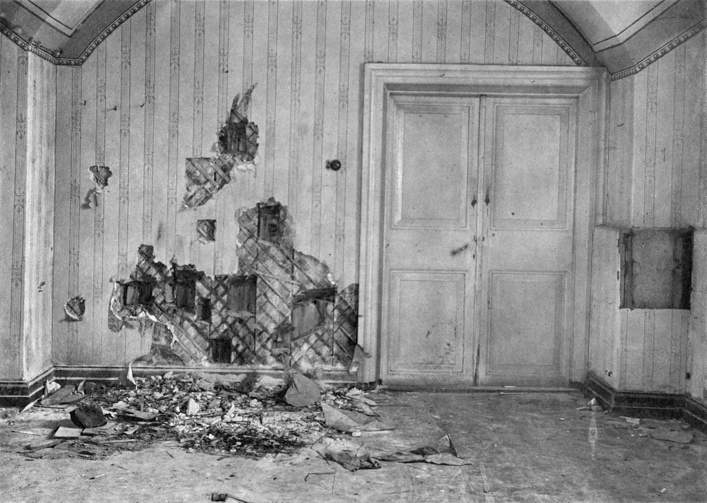 Пустая полуподвальная комната Ипатьевского дома со следами пуль на стене, снимок следствия