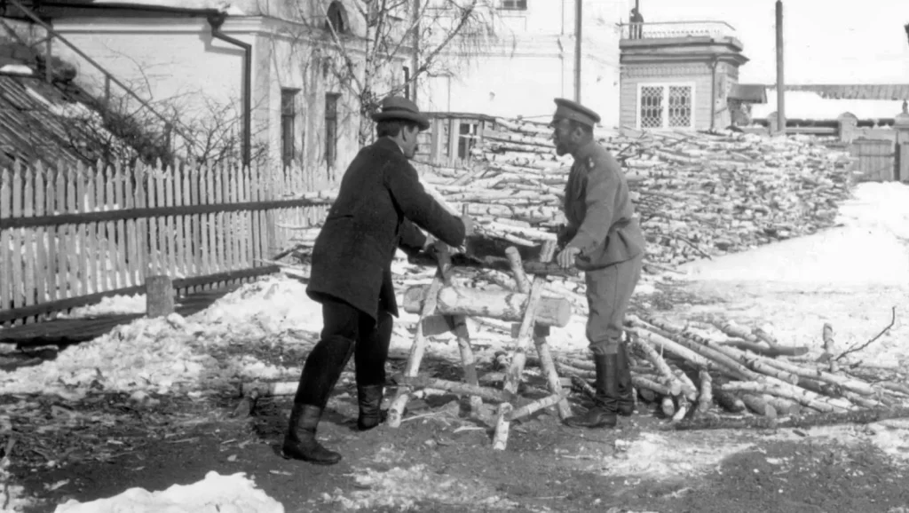Николай II и Пьер Жильяр пилят дрова во дворе в Тобольске зимой 1917–1918 годов