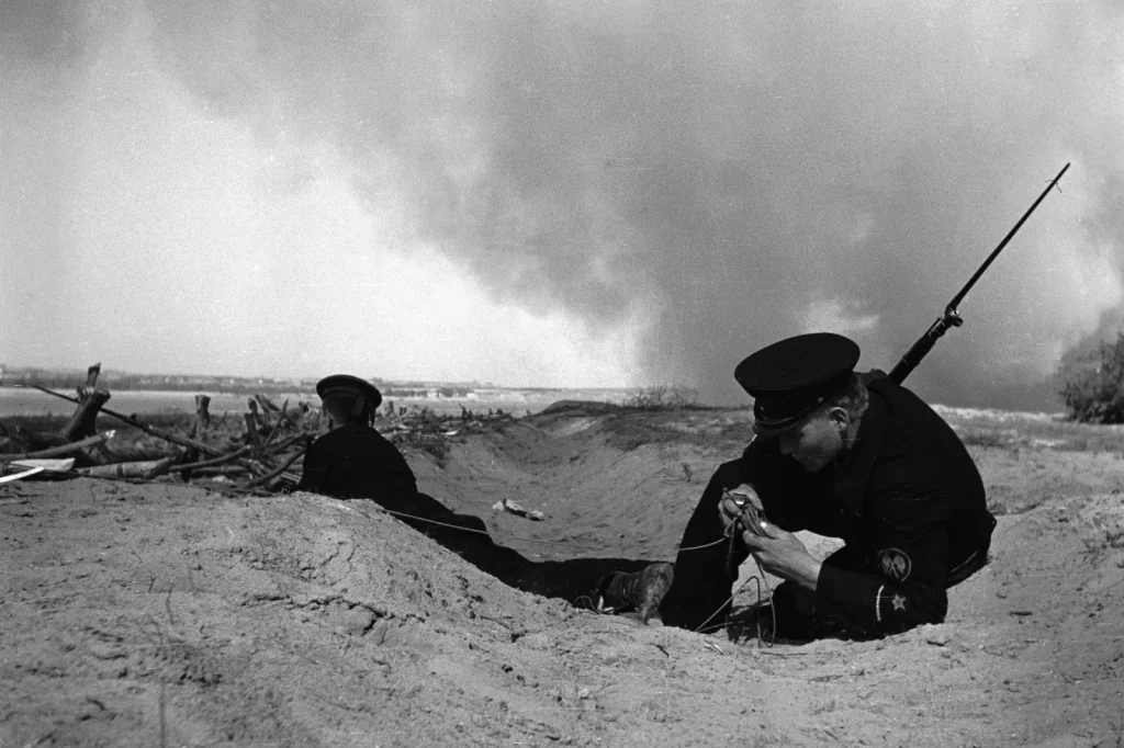 Краснофлотец в окопе на подступах к Сталинграду восстанавливает линию связи, август 1942 года