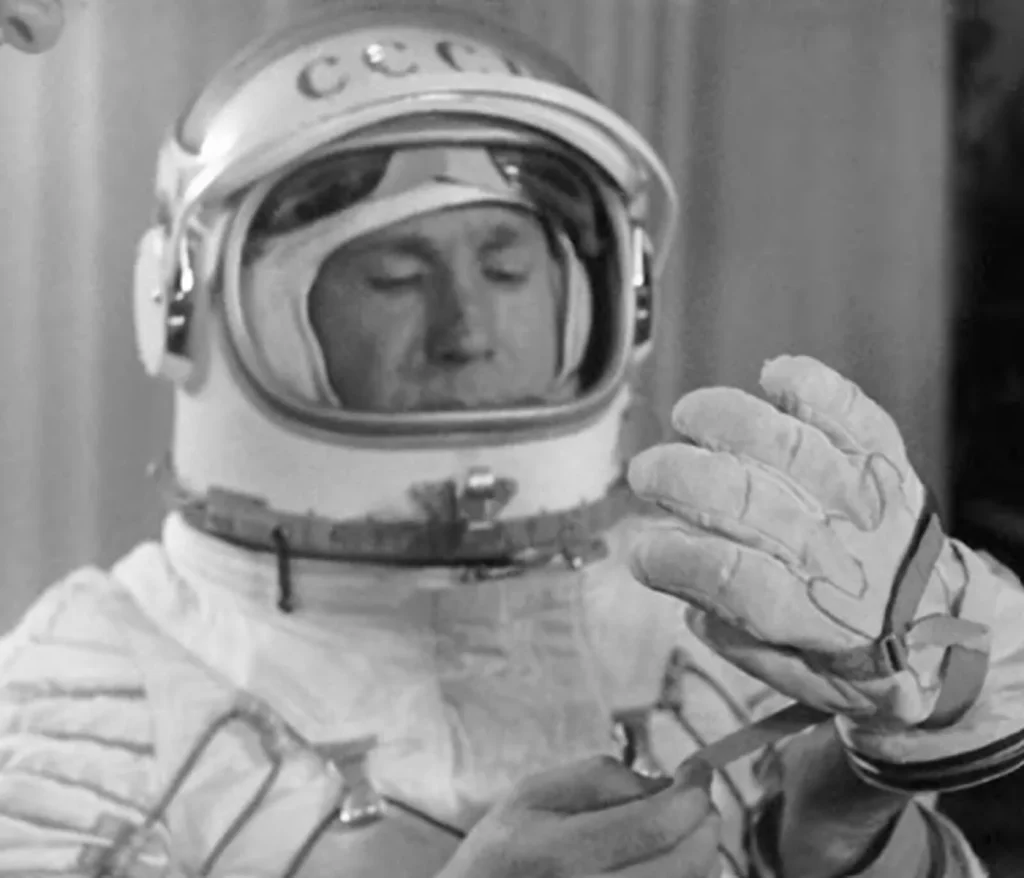 Алексей Леонов в скафандре со шлемом «СССР» поправляет перчатку, 1965 год